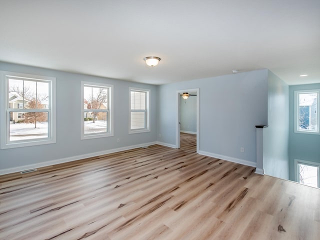 unfurnished room with ceiling fan, plenty of natural light, and light hardwood / wood-style flooring