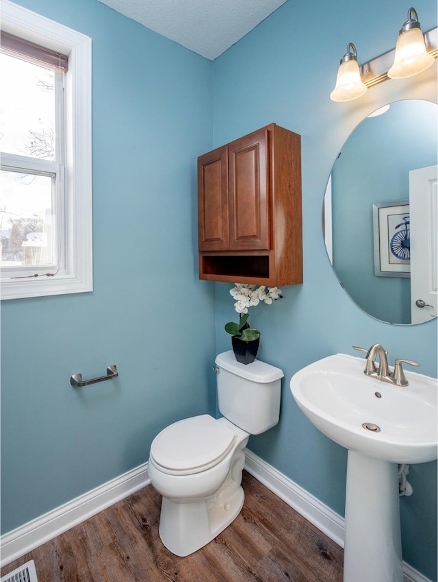 bathroom featuring toilet and wood-type flooring