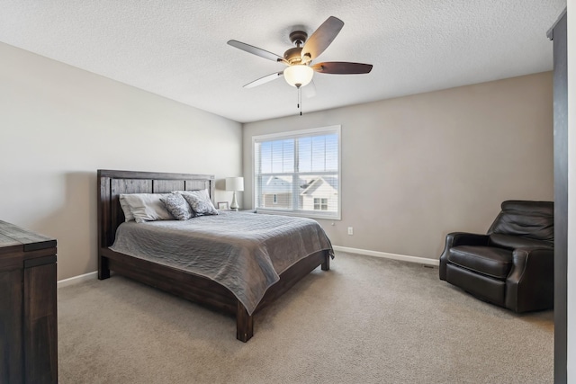 bedroom with ceiling fan, light colored carpet, and a textured ceiling