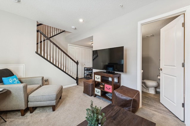 carpeted living room featuring a textured ceiling