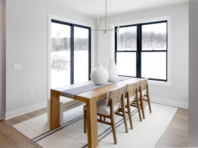 dining space with baseboards and light wood-style floors