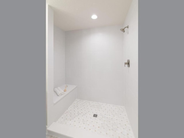 bathroom with a tile shower and recessed lighting