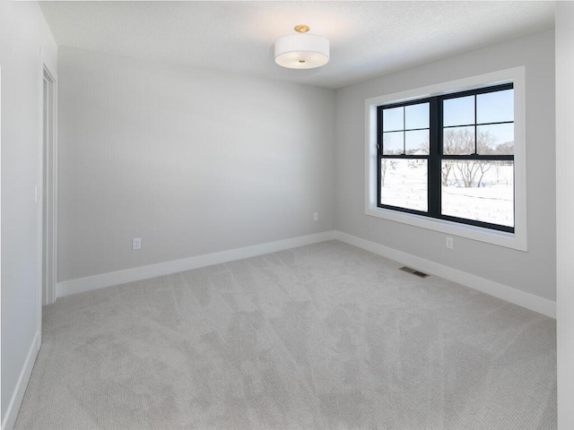 unfurnished room featuring baseboards, visible vents, a textured ceiling, and light colored carpet