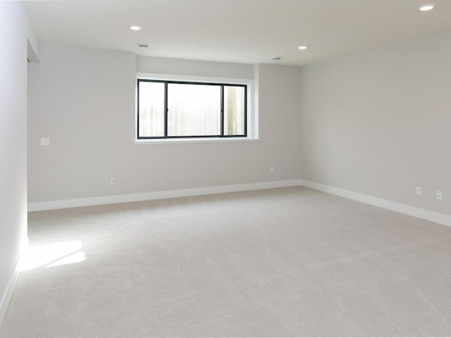 spare room with baseboards, light colored carpet, and recessed lighting