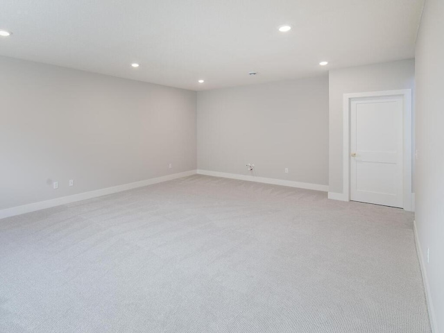 unfurnished room with recessed lighting, light carpet, and baseboards