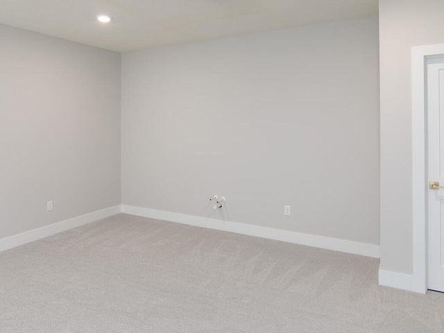 empty room featuring light carpet, recessed lighting, and baseboards