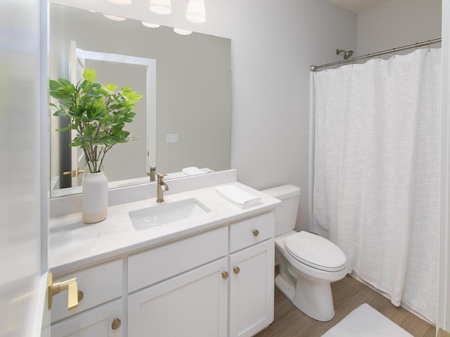 full bath featuring a shower with shower curtain, vanity, toilet, and wood finished floors