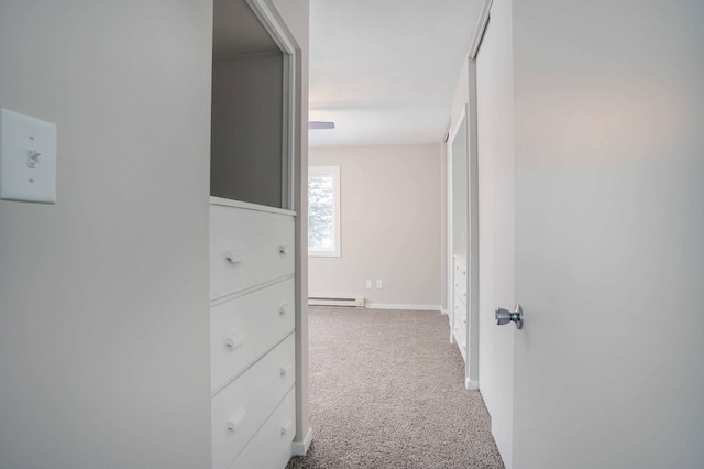 hallway with a baseboard heating unit and carpet flooring