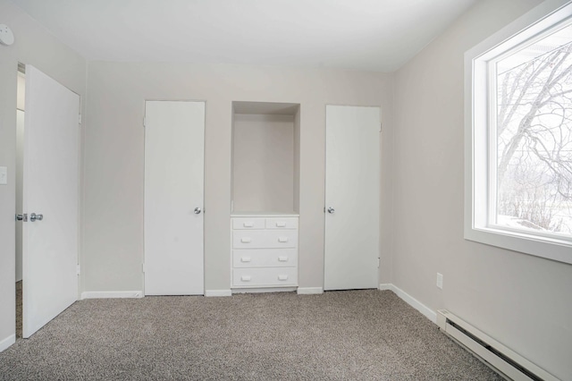 unfurnished bedroom featuring carpet and a baseboard heating unit