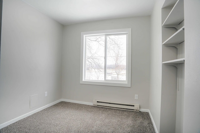 spare room featuring baseboard heating and carpet floors