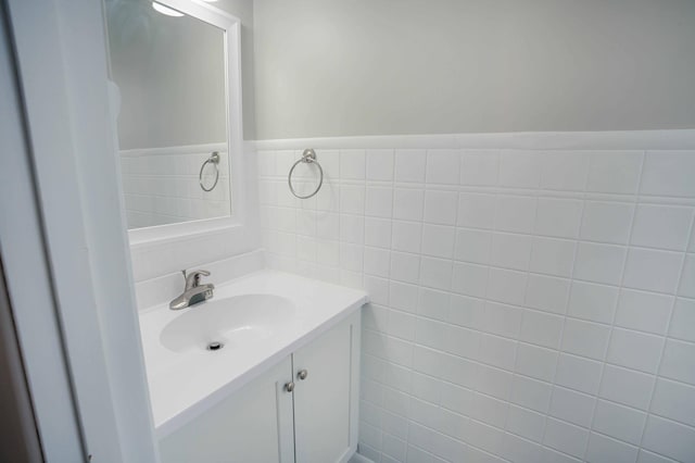 bathroom with vanity and tile walls