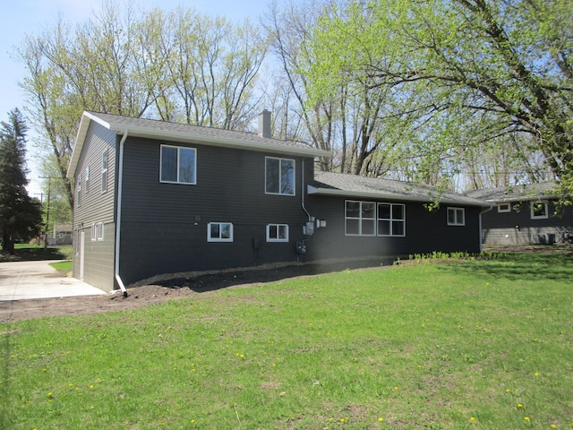 53 Eastview Dr, Hancock, MN 56244 - back of property featuring a chimney, a yard, driveway, and an attached garage