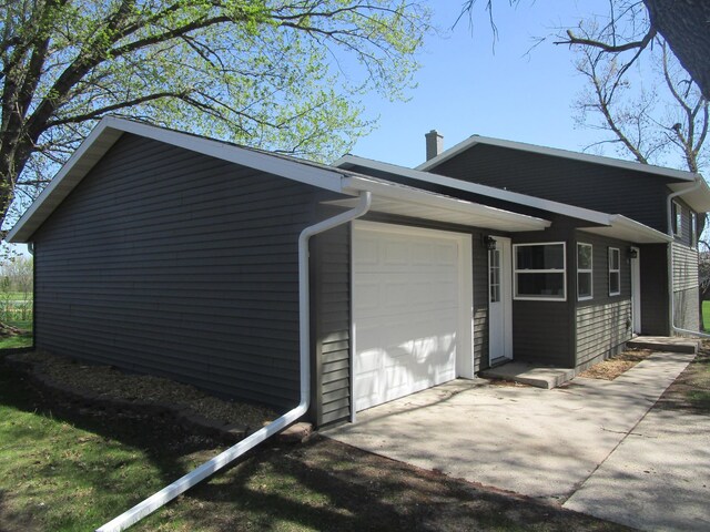 53 Eastview Dr, Hancock, MN 56244 - view of side of property featuring an attached garage, driveway, and a chimney
