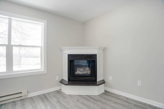 53 Eastview Dr, Hancock, MN 56244 - detailed view of a baseboard heating unit, wood finished floors, a glass covered fireplace, and baseboards