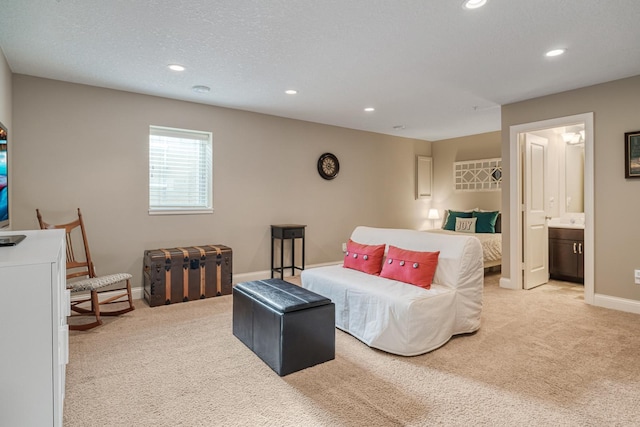 carpeted bedroom with ensuite bathroom and a textured ceiling