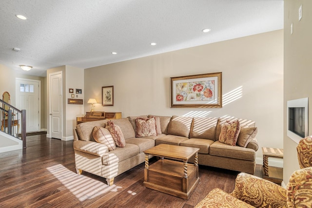 living room with dark wood-type flooring and a textured ceiling