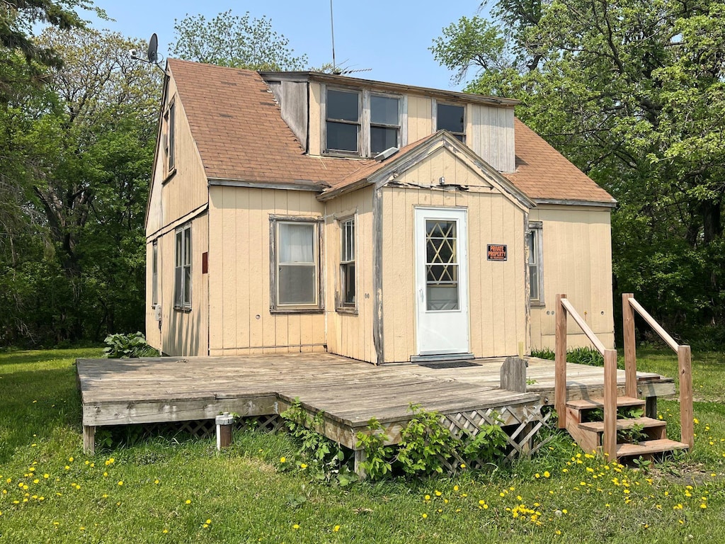 rear view of property featuring a wooden deck and a yard