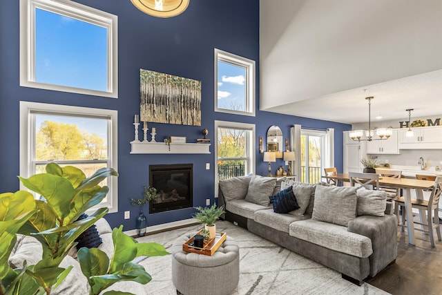 living room with a high ceiling, an inviting chandelier, and hardwood / wood-style floors