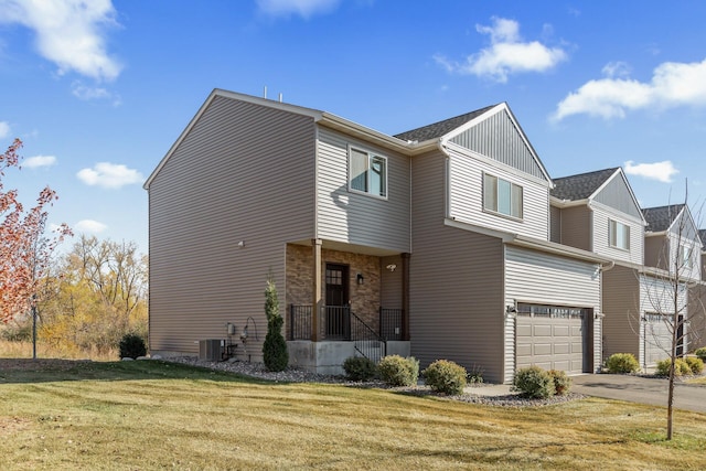 view of front of house featuring central air condition unit, a front lawn, and a garage