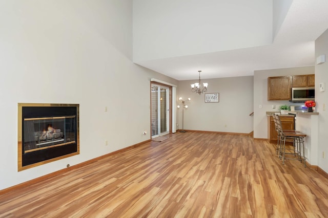 unfurnished living room featuring light hardwood / wood-style flooring and an inviting chandelier