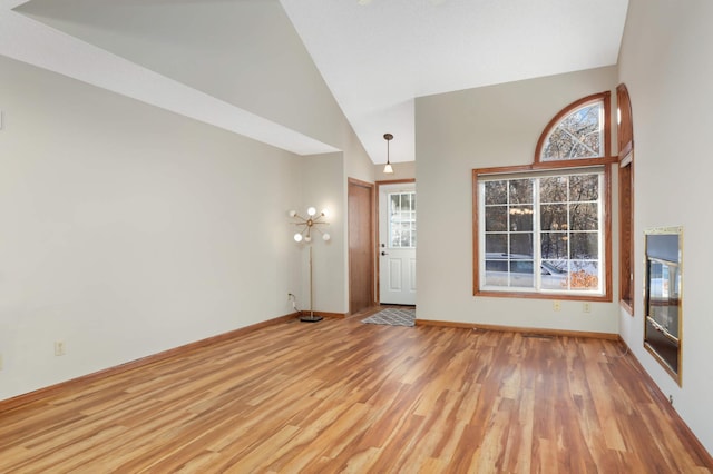 foyer with high vaulted ceiling and wood-type flooring