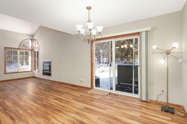 unfurnished dining area featuring light hardwood / wood-style floors, a healthy amount of sunlight, and a chandelier