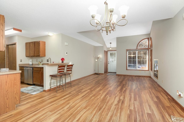 kitchen with light hardwood / wood-style floors, a notable chandelier, dishwasher, and hanging light fixtures