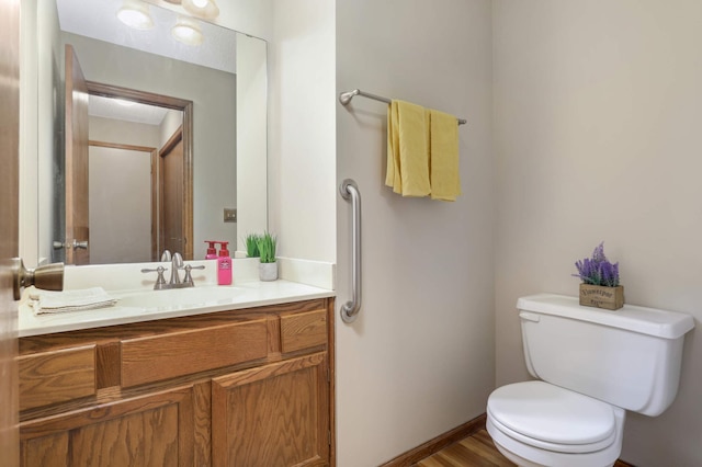 bathroom with hardwood / wood-style floors, vanity, and toilet