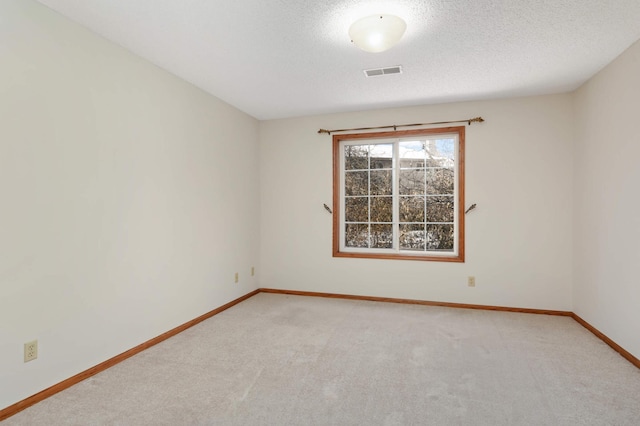 empty room with a textured ceiling and carpet flooring