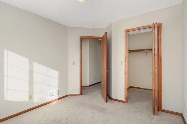 unfurnished bedroom featuring a closet and light carpet