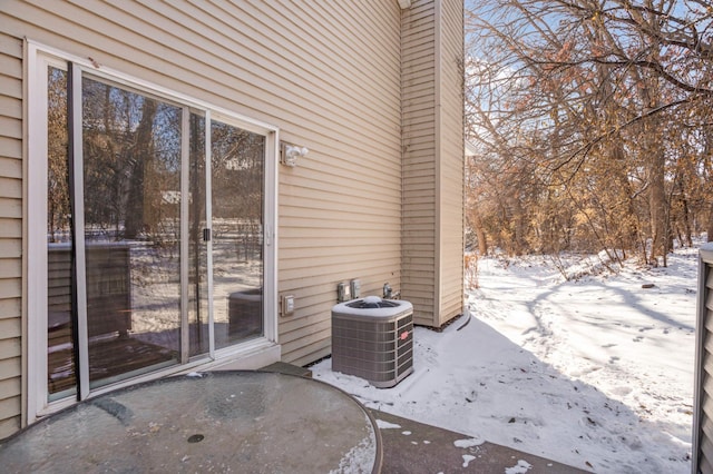 snow covered patio with cooling unit