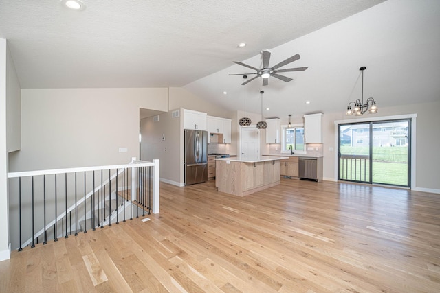 kitchen featuring light hardwood / wood-style floors, stainless steel appliances, a center island, white cabinetry, and decorative light fixtures