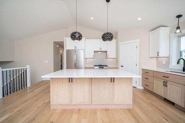 kitchen with stainless steel refrigerator, a spacious island, decorative backsplash, and white cabinetry