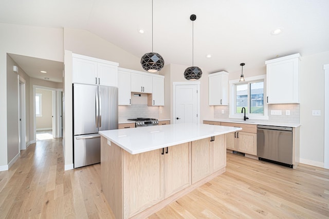 kitchen featuring stainless steel appliances, decorative backsplash, a kitchen island, lofted ceiling, and white cabinets