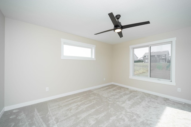 unfurnished room featuring ceiling fan, light carpet, and a healthy amount of sunlight