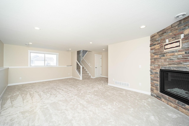 unfurnished living room with a fireplace and light colored carpet