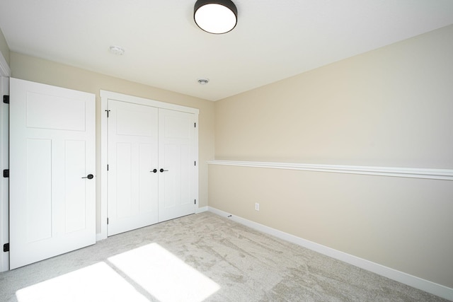 unfurnished bedroom featuring a closet and light carpet