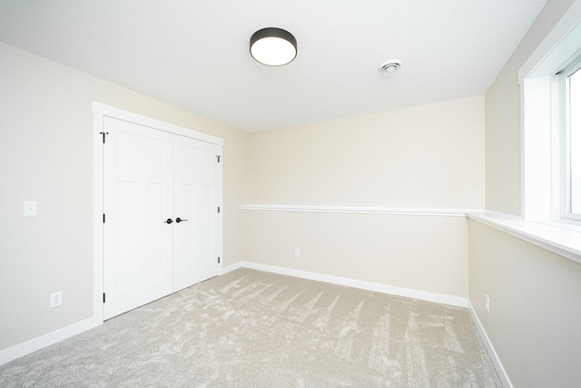 unfurnished room with light carpet