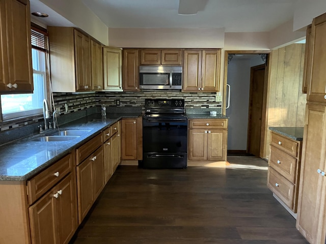 kitchen with decorative backsplash, dark wood-type flooring, dark stone countertops, black / electric stove, and sink