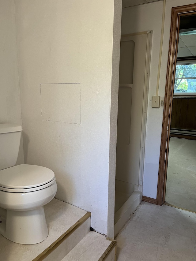 bathroom with baseboard heating and toilet