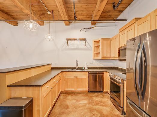 kitchen featuring stainless steel appliances, sink, track lighting, hanging light fixtures, and wood ceiling