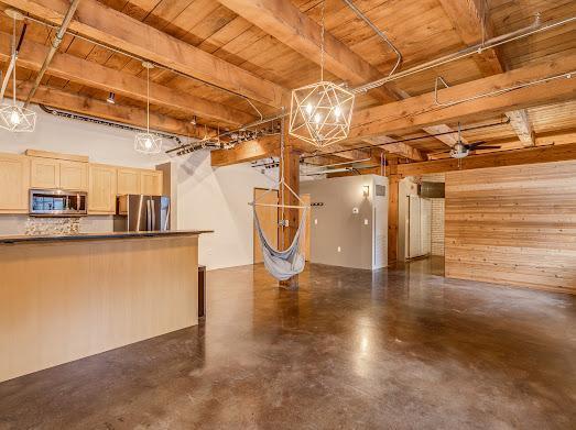 basement featuring wooden walls and stainless steel refrigerator