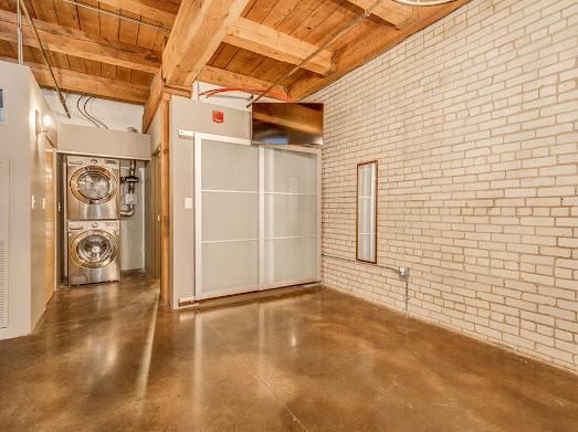 interior space featuring stacked washing maching and dryer and wooden ceiling