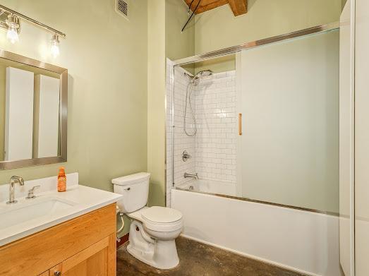 full bathroom with toilet, vanity, enclosed tub / shower combo, and beam ceiling