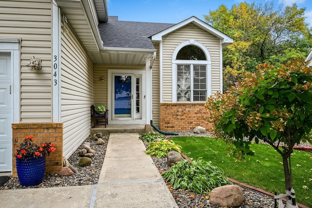 view of exterior entry featuring a lawn