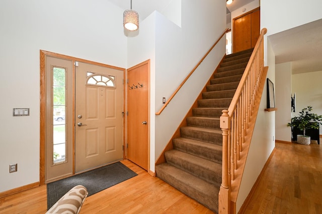 foyer entrance featuring plenty of natural light, a towering ceiling, and hardwood / wood-style floors