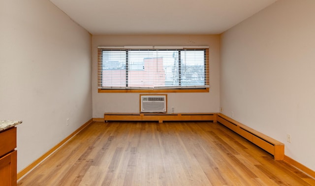 unfurnished room with light wood-type flooring and an AC wall unit