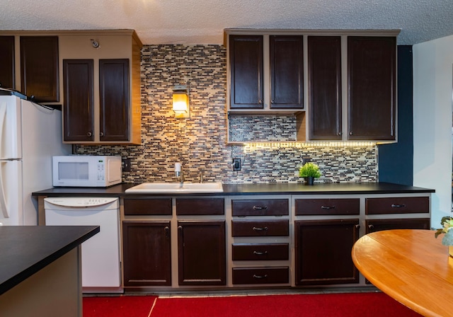 kitchen featuring backsplash, white appliances, a textured ceiling, dark brown cabinetry, and sink