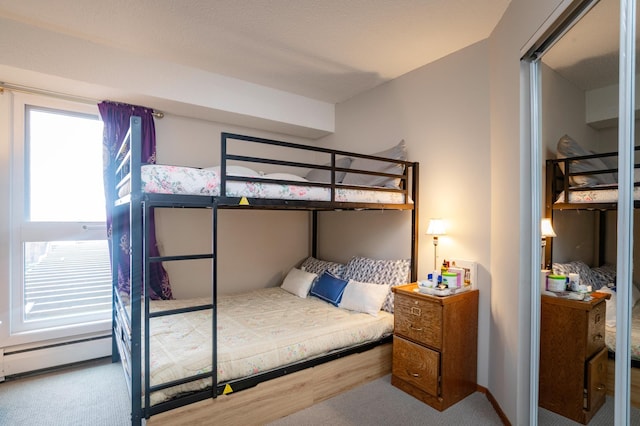 bedroom with a baseboard heating unit and carpet floors