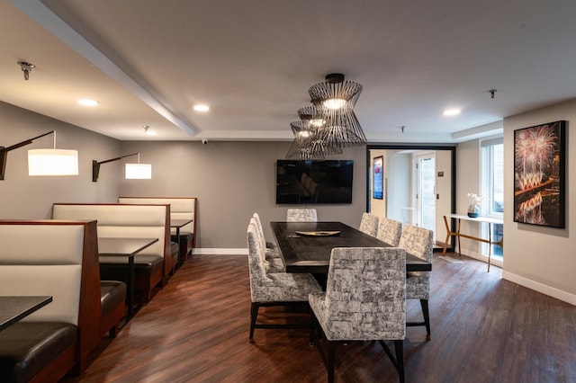 dining space with dark hardwood / wood-style flooring and a chandelier